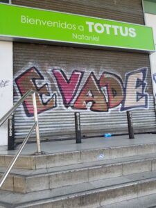 photo of supermarket security door with EVADE graffiti